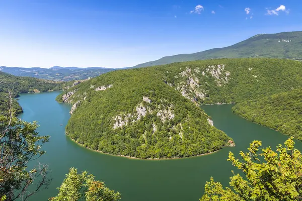 Bosna-Hersek, Avrupa 'daki Vrbas Nehri' ndeki kanyon. Bereketli yeşil ormanları ve açık mavi gökyüzünün altında sarp kayalıkları olan yemyeşil nehir vadisi. Yükselmiş bir bakış açısından sakin doğa sahnesi.