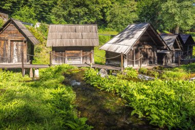 Bosna-Hersek 'in Jajce kasabası yakınlarındaki Pliva Nehri' ndeki Mlincici ahşap su değirmenleri. Nehir kenarındaki ahşap yapıların manzarası.