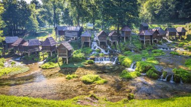 Bosna-Hersek 'in Jajce kasabası yakınlarındaki Pliva Nehri' ndeki Mlincici ahşap su değirmenleri. Nehrin kenarında eski ahşap su değirmenleri var. Büyüleyici tarihi bir manzara..