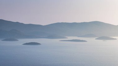 Hırvatistan 'ın güneyindeki Dalmaçya' daki Peljesac yarımadası. Kıyıya yakın küçük adaların bulunduğu sakin okyanus manzarası, sisli dağlarla destekleniyor. Huzurlu deniz manzarası.