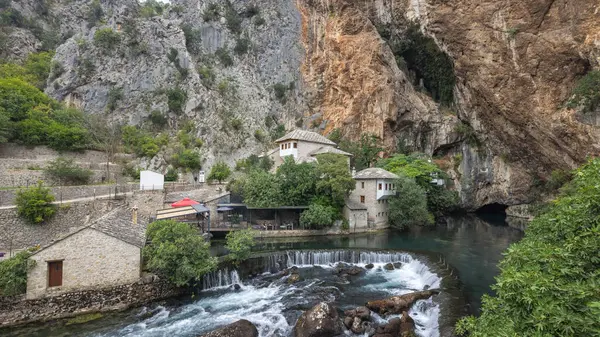 Bosna-Hersek 'in Mostar kenti yakınlarında Buna nehri olan Blagaj Tekke manastırı, Avrupa. Resimli köy, yüksek uçurumların dibine kurulmuş, tarihi binaların arasından akan nehir..