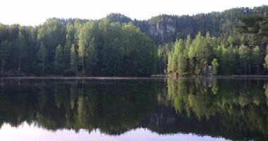 Çek Cumhuriyeti 'nin Avrupa' daki Hradec Kralove Bölgesi 'ndeki Adrspach-Teplice Kayalıkları bölgesinde bulunan Piskovna Gölü. Bereketli bir ormanı yansıtan sakin bir göl ve sakin bir gökyüzünün altında görkemli kaya oluşumları.