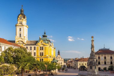 Pecs, Macaristan - 13 Temmuz 2024: Szechenyi Meydanı. Çarpıcı bir mimari ve açık mavi gökyüzü ile Avrupa şehir meydanının çarpıcı manzarası, pitoresk bir şehir manzarası yaratıyor..