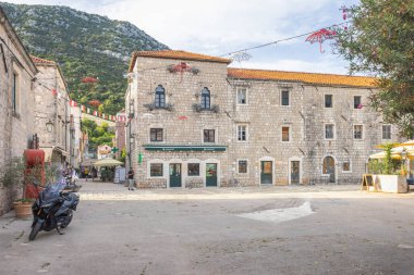 Ston, Hırvatistan - 7 Temmuz 2024: Peljesac yarımadasındaki tarihi kent. Avrupa Şehir Meydanı: Taş binalar, kaprisli şemsiyelerle süslenmiş ve eski dünya mimarisi sergilenen bir plazanın yan taraflarında yer alıyor.