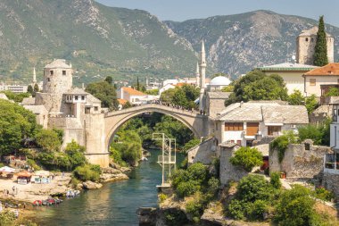 Mostar, Bosna-Hersek - 9 Temmuz 2024: Stari Most köprüsü, Neretva Nehri üzerindeki eski köprü. Resimli taş köprü tarihi şehirde turkuaz nehri boyunca uzanır..