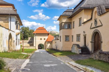Spisska Kapitula, an ecclesiastical town in region of Spis in Slovakia, Europe. Charming European town with historic architecture, featuring a tower and building against a partly cloudy sky backdrop.