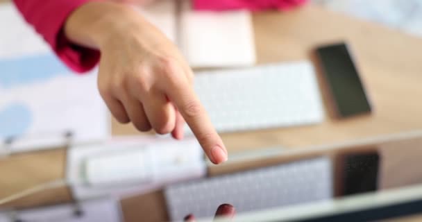 女性の指は職場のコンピュータモニタを指している 事業情報の慎重な検討 — ストック動画