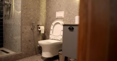 Modern banyo beyaz klozeti, gri tonlarda, basit bir şekilde. Modern banyo tasarımı.