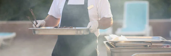 シェフのクローズアップは 調理された食事 フライパンの食べ物のための金属構造を運ぶ グリルを行う 屋外でピクニック 肉や野菜をフライパン ストリートフード バーベキューのコンセプト — ストック写真