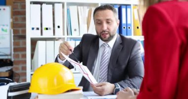 Tasarımcı mimar müşteriyle inşaat projesini tartışıyor. İnşaat planlama kavramı