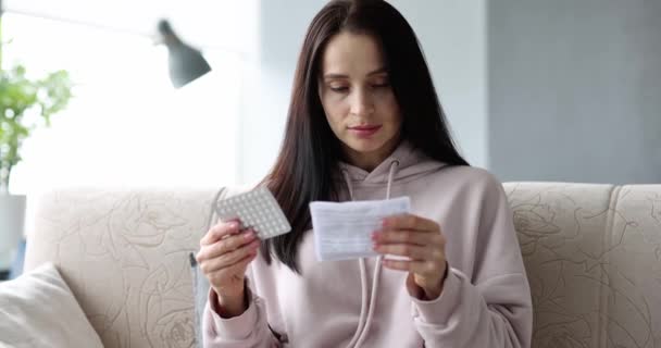 妇女手里拿着一小包起泡的药丸 阅读医疗说明 服用药物概念的规则 — 图库视频影像