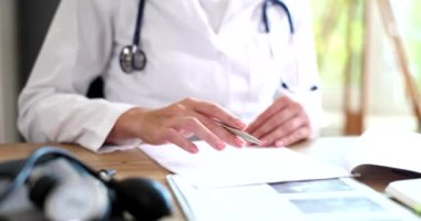 Kardiyogram çizelgesi ve hasta tıbbi geçmişi olan doktor elleri. Nabız aritmisini ölçen kardiyoterapist belgesi