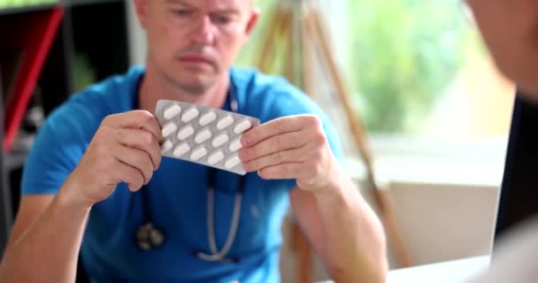 Médico Masculino Examina Cuidadosamente Las Píldoras Paquete Ampollas Paciente Clínica — Vídeos de Stock