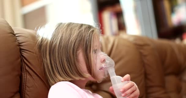 女の子は自宅でネブライザーを使って吸入を行います 子供用酸素マスク — ストック動画