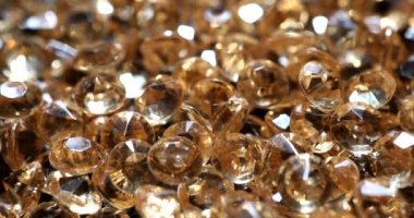 Birçok sarı mücevher soyut arka planda 4k 'lık filmi yavaş çekimde kapatır. Elmas satışı konsepti