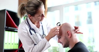 Doktor trichologist kel erkek hasta 4K film ağır çekimde kafa derisini inceliyor. Erkekler kavramında alopecia tedavisi