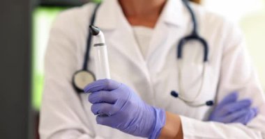 KBB doktoru klinikte beyaz dijital otoskop tutuyor. Otorhinolaryngolog kulak boğaz ve burun hastalıklarını önleme ve tedavi etmekle meşgul.