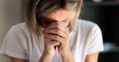 Mutsuz genç bir kadın, çaresizce ihanete uğramış gibi elleriyle yüzünü kapatıyor. Evde yalnız başına umutsuz bir kadın