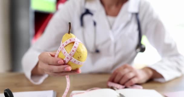 女医生拿着黄色的梨子 用厘米量一量 适当的营养营养学家和饮食 — 图库视频影像