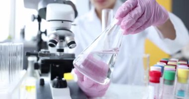 Bilim adamı cam şişeyi şeffaf sıvıyla tutuyor. Bilimsel araştırma suyu kavramı