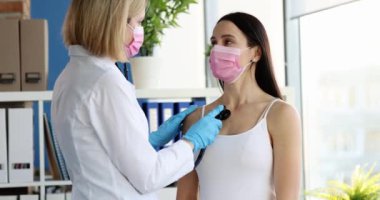 Doktor, klinikteki kadın hastaların akciğerlerini steteskopla dinliyor. Zatürree ve grip konseptiyle öksürük