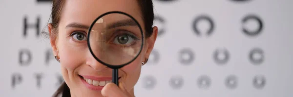 眼科医は眼科診療所の虫眼鏡を通して見ています 遠視の治療 近視と禁欲主義の概念 — ストック写真