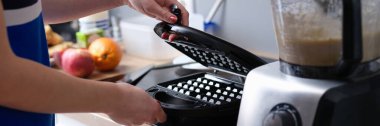 Kadın, Viyana ve Belçika gözlemeleri için elektrikli waffle makinesi açıyor. Örnek mutfak aleti modeli
