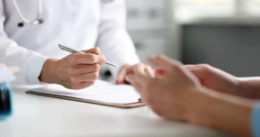 Doktor hasta bir hastanın ellerine tıbbi geçmişin listesini kağıt listeye yazar. Sağlık ve hastalık önleme kavramı