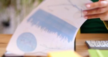 Finansal veriler ve grafiklerle birlikte bilgisayar ekranının önündeki klavyenin üzerindeki kadın eller. Grafikler ve satış istatistiklerinde veri analizi
