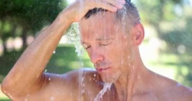 Duşun altında duran bir adamın portresi ya da serin akıntıdan hoşlanan bir adam. Yakışıklı bir adam ve yaz duşunda üşüyor.