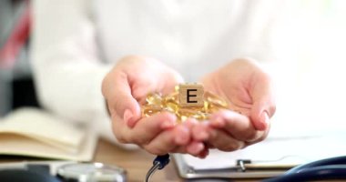 Doktor elinde vitamin ve balık yağı kapsülleri var. Vitaminler cilt sağlığı için iyidir.