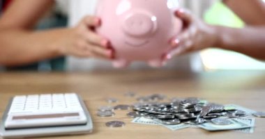 Domuz kumbarası dolusu para ve hesap makinesi. Finansal bütçe depozitosu ve tasarruflarda kârlı yatırım