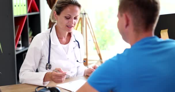 Γυναίκα Γιατρός Ελέγχει Την Υγεία Των Ασθενών Και Εξηγεί Την — Αρχείο Βίντεο