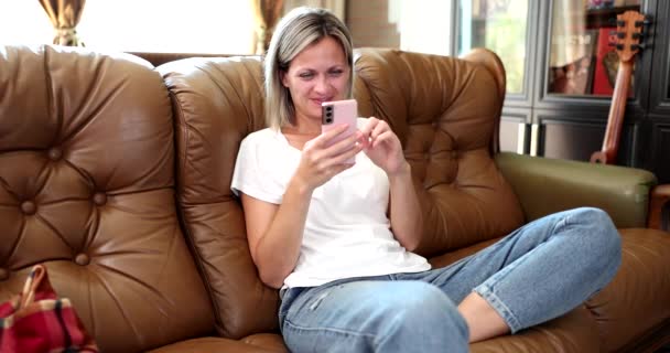 Preciosa Mujer Sonriente Despreocupada Sentada Sofá Con Teléfono Inteligente Casa — Vídeo de stock