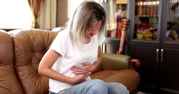 Kobieta Siedzi Kanapie Trzymając Się Brzuch Powodu Silnego Bólu Brzucha — Wideo stockowe