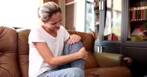 Oturma Odasında Kanepede Oturan Kadın Dizlerinde Bacaklarında Ağrıdan Muzdarip Masaj — Stok video