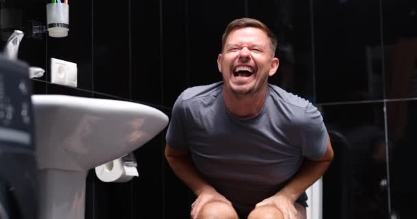 男人在厕所里的厕所里 感情上遭受痔疮的折磨 便秘和肠道问题 — 图库视频影像