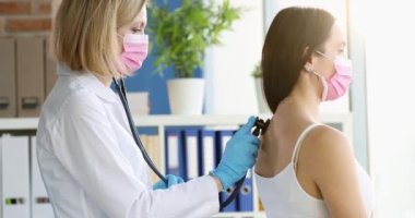 Steteskoplu doktor kalp atışlarını ve nefes alışlarını dinliyor. Zatürree teşhisi ve koronovirüs enfeksiyonu kavramı