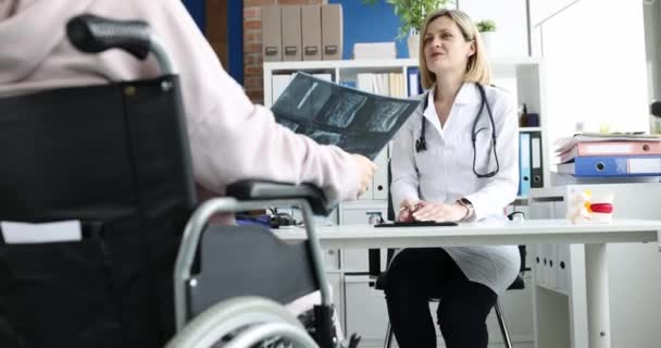 Врач Обсуждает Рентген Позвоночника Пациентом Инвалидом Восстановление После Травм Концепции — стоковое видео