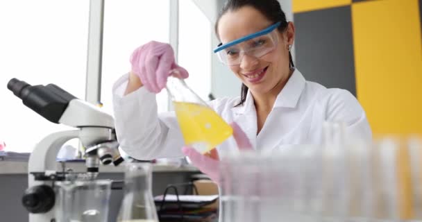 实验室里拿着装有黄色液体的瓶子微笑的科学家 有毒石油概念的化学研究 — 图库视频影像