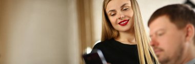 Gülümseyen güzel sarışının portresi akıllı telefondan adama fotoğraf gösteriyor. Yakışıklı, şık makyajlı bir kadın, erkeklerle iletişim kuruyor. Kırmızı dudaklar ve güzellik