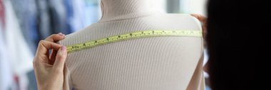 Close-up of female fashion designer takes measurements with centimeter. Tailor woman sewing fashion clothes. Designer, art and sewing concept