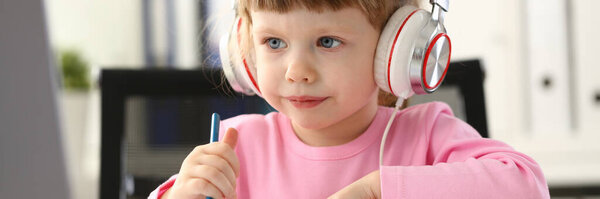 Portrait of little girl wearing headset, fun pastime or online education. Childhood, development or preschool class concept