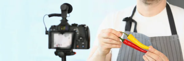 男厨师在围裙中的特写镜头 在镜头前显示辣椒 Blogger为Vlog录制视频 Hobby Making Content Video Vlog Concept — 图库照片