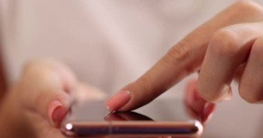 Kadınların parmakları akıllı telefon ekranını kaydırıyor, yakın plan. Telefondaki uygulamayı kullanarak, sığ odak