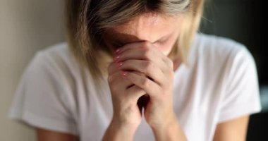 Kadın başını eğdi ve ellerini yüzüne koydu, yakın çekim, yavaş çekim. Tanrı için duayı kabul et.