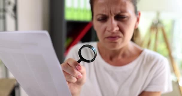 Kvinna Läser Ett Dokument Genom Ett Förstoringsglas Närbild Grunt Fokus — Stockvideo