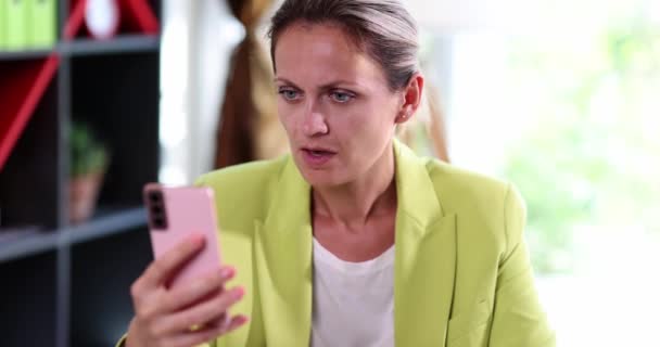 Γυναίκα Στο Γραφείο Κοιτάζει Smartphone Και Χτυπάει Τον Εαυτό Της — Αρχείο Βίντεο