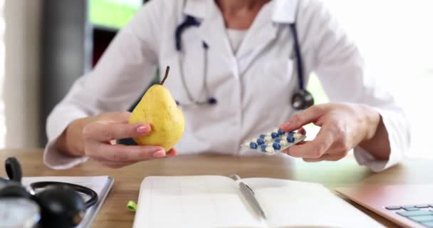 Woman Doctor Holds Out Pills Pear Close Visit Nutritionist Appointment — Stock Video