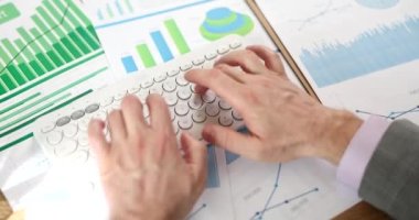 İşadamı elinde matematiksel finans analizi ve istatistikleri için bilgisayar klavyesi tutuyor. Vergilendirme ve analitik araştırma kavramı